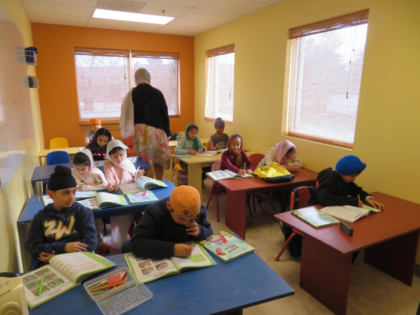 Students working in Punjabi workbooks at GAISS